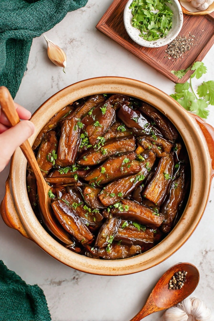A round beige clay pot filled with a dark brown sauce holding many long, shiny, brown eggplant strips cooked to softness, sprinkled with small chopped green herbs on top. One woman's hand holds the pot handle on the left side, while the other woman's hand uses a silver spoon to scoop some eggplants from the pot. In the top right corner, there is a small white bowl with fresh cilantro, black pepper on a wooden spoon, and a wooden tray with a few small green herb leaves. The background is a white marbled surface with a green cloth partially seen at the bottom left and a garlic clove at the bottom right. Photo taken with an iphone --ar 2:3 --v 7