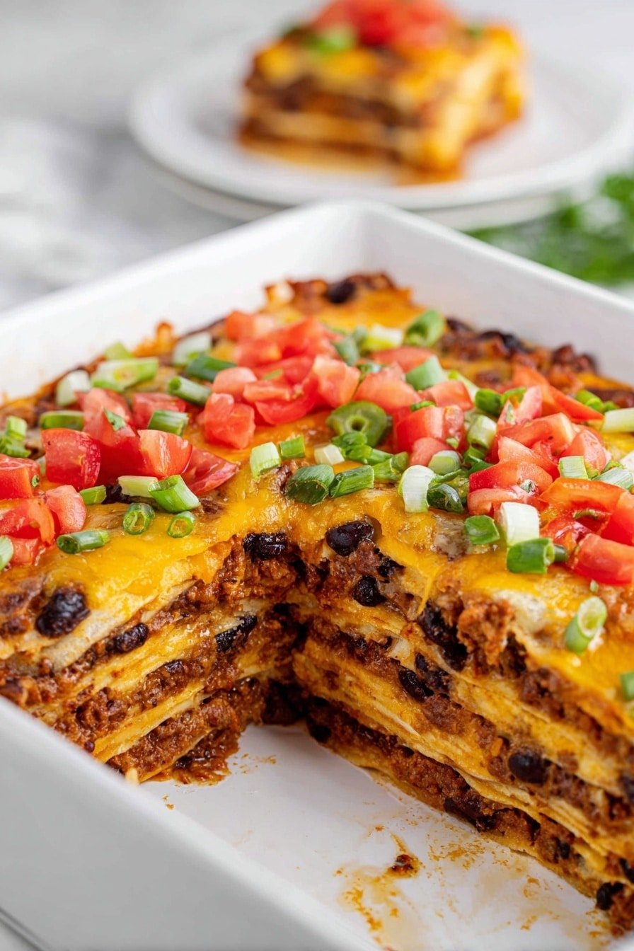 The image shows a layered casserole in a white rectangular dish on a white marbled surface. The dish has five visible layers: the bottom and middle layers are soft yellow tortillas, separated by layers of orange melted cheese, and a filling made of dark brown cooked ground meat mixed with black beans. The top layer is a baked cheese topping mixed with more cooked meat and beans, and it is decorated with bright red diced tomatoes and chopped green onions scattered on top. A square piece of the casserole has been removed, revealing the layers inside. In the blurred background, there is a white plate holding a slice of the casserole. Photo taken with an iphone --ar 2:3 --v 7