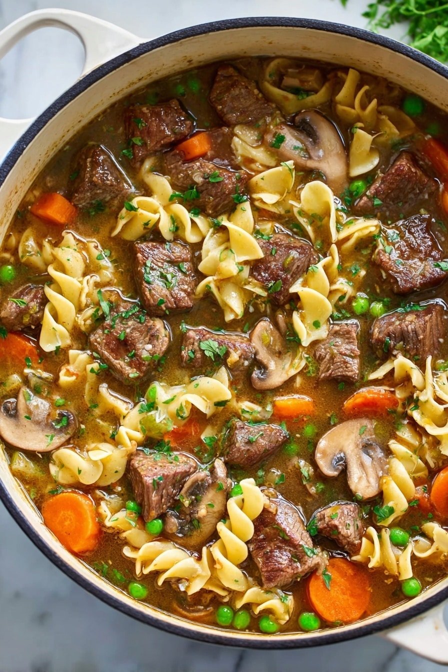 The image shows a white pot filled with a rich beef stew layered with several ingredients. Large chunks of brown cooked beef are scattered throughout the stew, mixed with thick slices of brown mushrooms. Bright orange carrot slices and small green peas add color contrast next to curly yellow pasta pieces that float on the surface. The broth is light brown and slightly thick, with visible chopped green herbs sprinkled over the top. The pot sits on a white marbled surface with green herbs blurred in the background. photo taken with an iphone --ar 2:3 --v 7