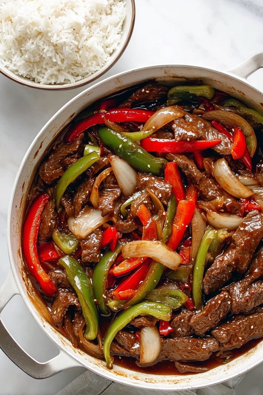 The image shows a white pan filled with stir-fried slices of brown beef mixed with long strips of red and green bell peppers and thick slices of translucent cooked onions, all coated in a glossy brown sauce. Next to the pan, there is a bowl filled with white rice. The background is a white marbled surface. photo taken with an iphone --ar 2:3 --v 7
