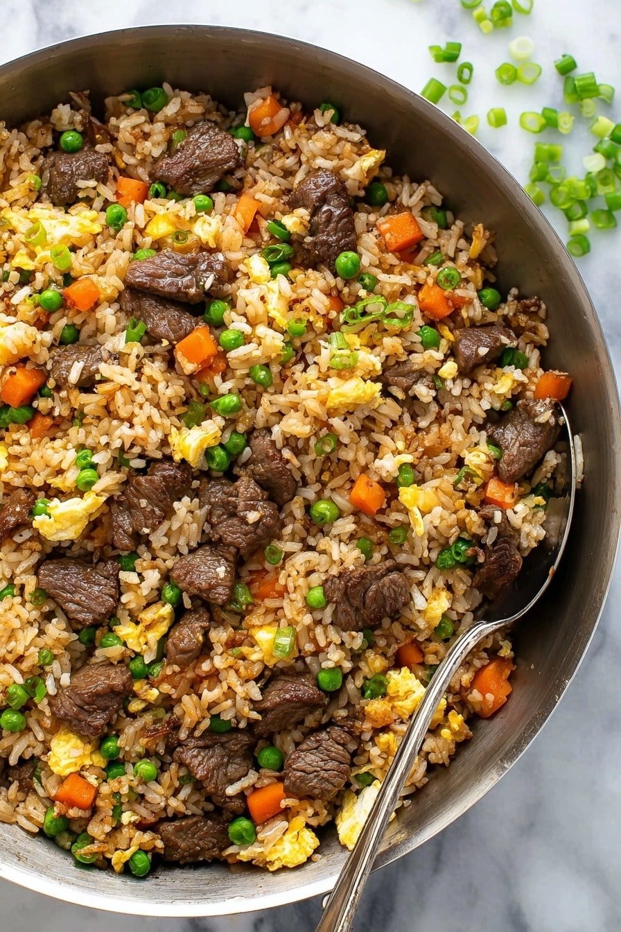 A pan filled with fried rice mixed with small pieces of brown grilled beef, orange carrot cubes, bright green peas, and yellow scrambled eggs. The rice is light brown with a shiny texture, spread evenly through the pan. Some chopped green onion pieces are sprinkled on top, adding small bright green spots. A silver spoon rests in the pan on the right side. The background shows a white marbled surface with some scattered green onion pieces. photo taken with an iphone --ar 2:3 --v 7