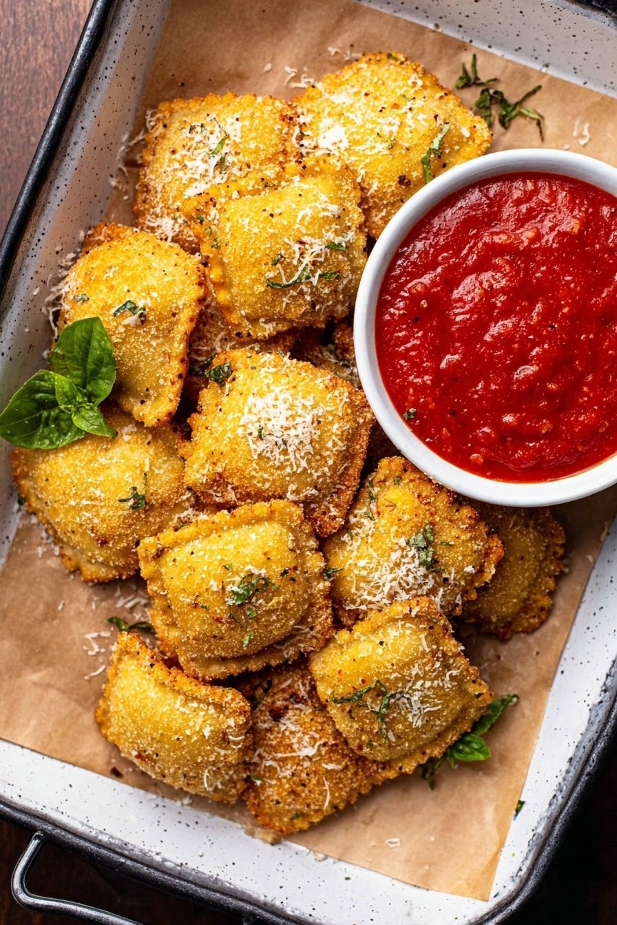 A group of small, round, golden-brown fried balls with a crumbly texture is piled on white parchment paper inside a white tray with dark handles visible. Some balls have small bits of green herbs and grated pale cheese sprinkled on top. To the top right, a white bowl filled with thick, bright red sauce is placed on the parchment, contrasting with the golden balls. A few green leaves peek from under the balls on the left side. The whole scene sits on a white marbled surface. photo taken with an iphone --ar 2:3 --v 7