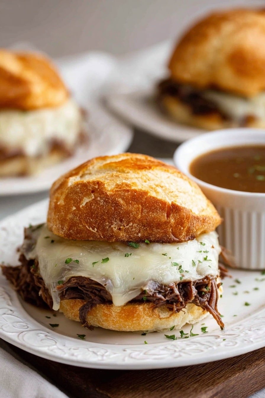 A close-up view of a sandwich with three layers inside a white ciabatta roll on a white marbled surface. The bottom layer is shredded dark brown meat, topped with a thick layer of melted white cheese with small green herbs sprinkled on it, and the top is a golden-brown crusty bread piece with clear texture lines. The sandwich sits on white parchment paper on a silver tray, with a second sandwich blurred in the background on a white plate. Two small bowls of brown gravy are also visible, one in the foreground and one slightly blurred in the background. photo taken with an iphone --ar 2:3 --v 7