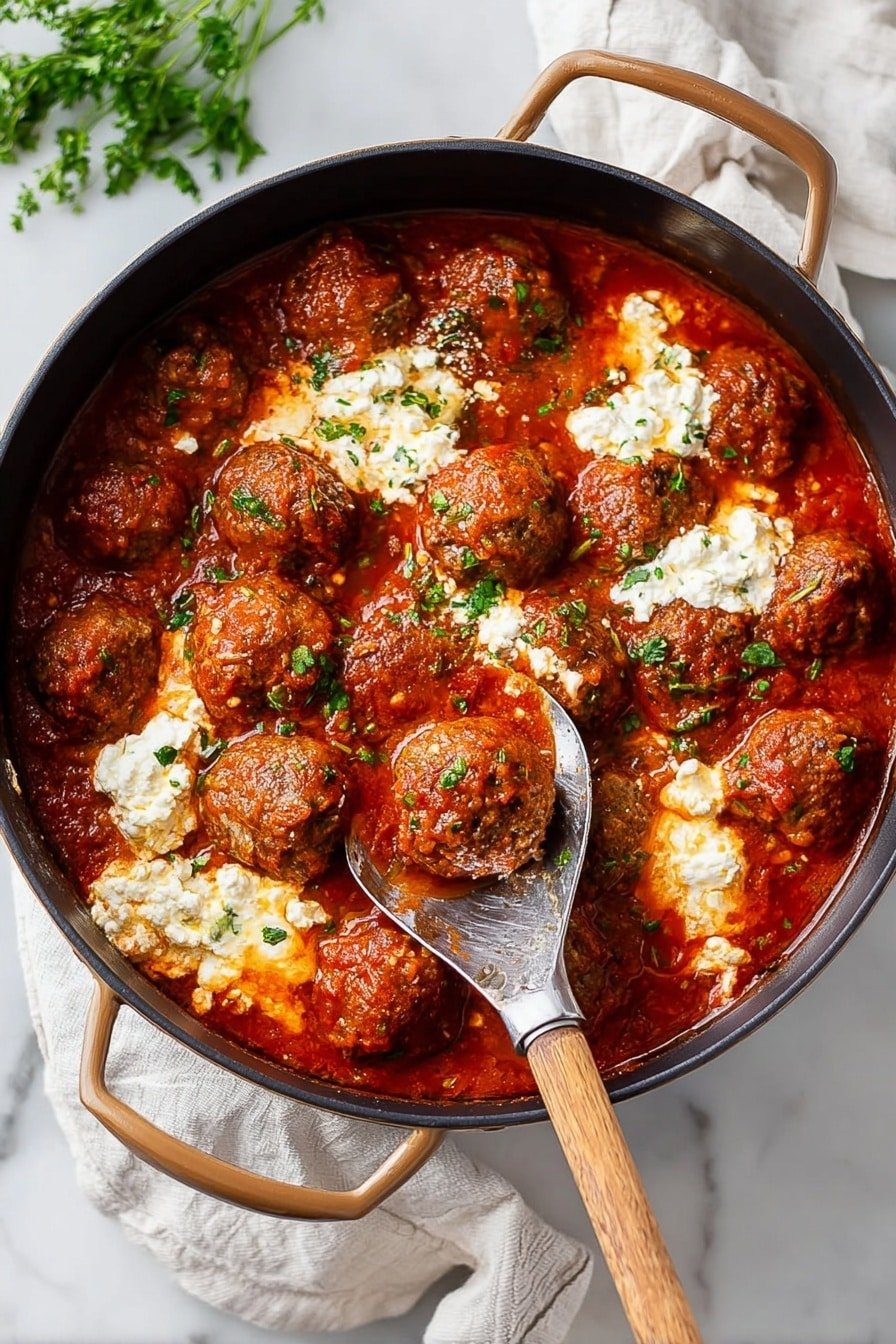 A black round pot filled with many brown meatballs covered in rich red tomato sauce that has a slightly chunky texture, with white dollops of creamy ricotta cheese mixed throughout, topped with small green herb pieces. A wooden spoon with a metal handle is resting inside the pot, scooping some meatballs and sauce. The pot is placed on a white marbled surface with a white cloth nearby and some green herbs on the side. photo taken with an iphone --ar 2:3 --v 7