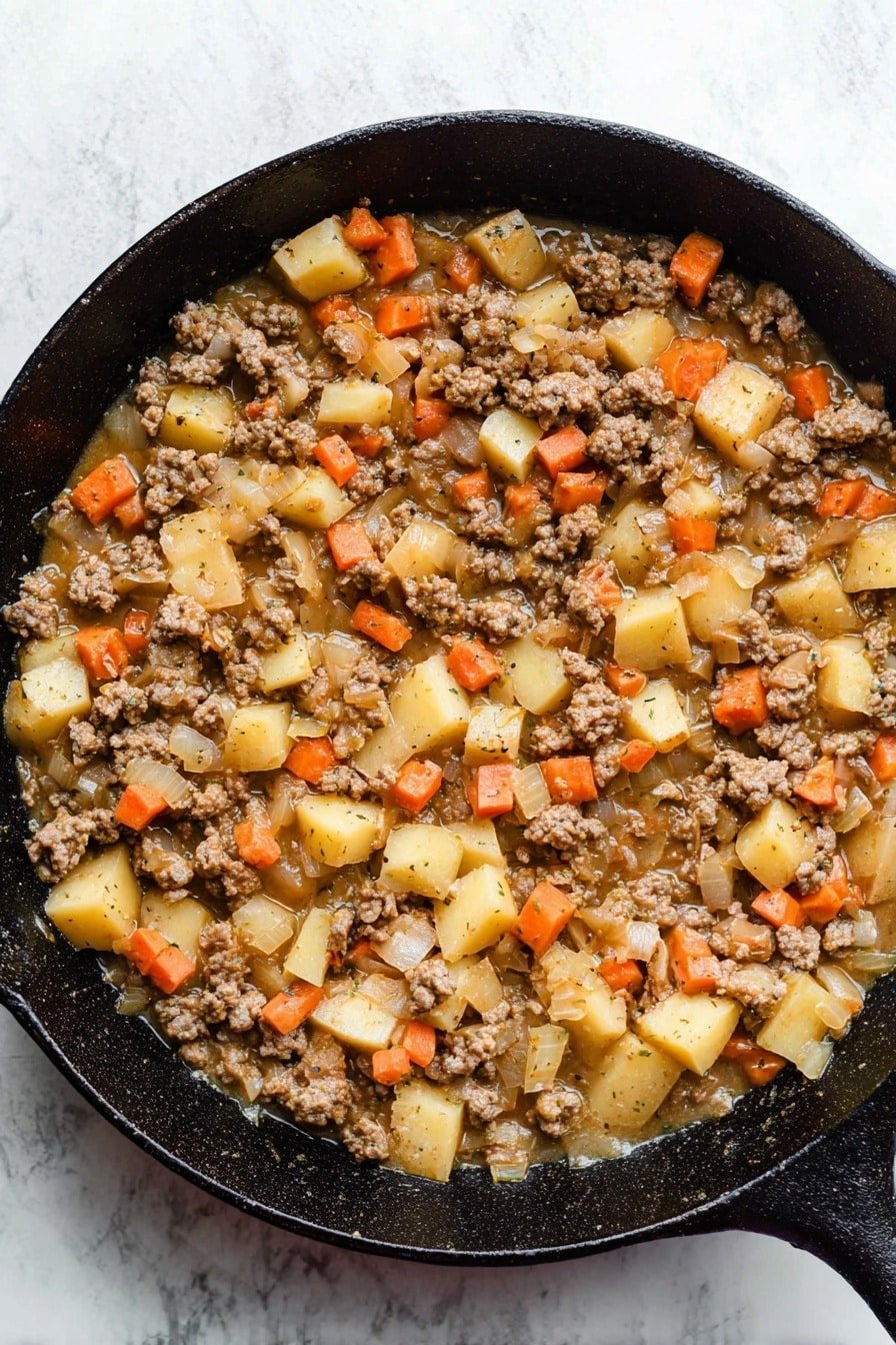 The image shows a black cast iron pan filled with a cooked mixture of ground meat, diced potatoes, small orange carrot cubes, and chopped translucent onions, all covered in a light brown sauce. The meat pieces are crumbly and brown, while the potatoes and carrots have a soft texture and are scattered evenly throughout the pan. The pan is set on a white marbled texture surface with the mixture appearing warm and freshly made. Photo taken with an iphone --ar 2:3 --v 7