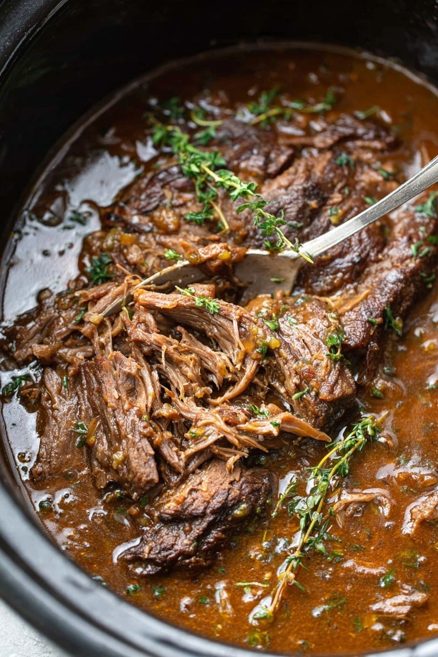 A close-up view of a thick piece of brown cooked meat partially shredded in a dark pot with rich brown gravy covering the meat and pooling beneath it. The meat looks tender with visible fibers, and fresh green thyme sprigs are scattered on top, adding texture and a pop of color. A silver fork is stuck in the shredded part of the meat, and the scene is set against a white marbled texture background. photo taken with an iphone --ar 2:3 --v 7