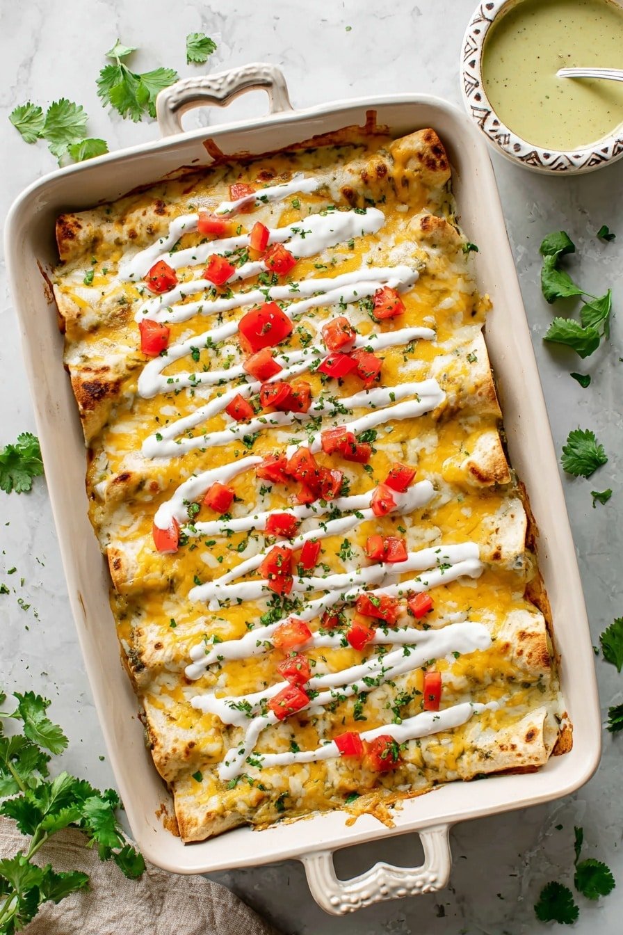 The dish shows a rectangular ornate white baking dish filled with three layers of enchiladas covered in melted yellow and white cheese. The top layer is drizzled with white sauce in horizontal lines and sprinkled with small red diced tomatoes and chopped green herbs. The edges of the enchiladas are slightly browned, giving a baked texture. The baking dish sits on a white marbled surface with scattered green cilantro leaves around it. To the upper right side, there is a small ornate white bowl filled with a light green sauce. photo taken with an iphone --ar 2:3 --v 7