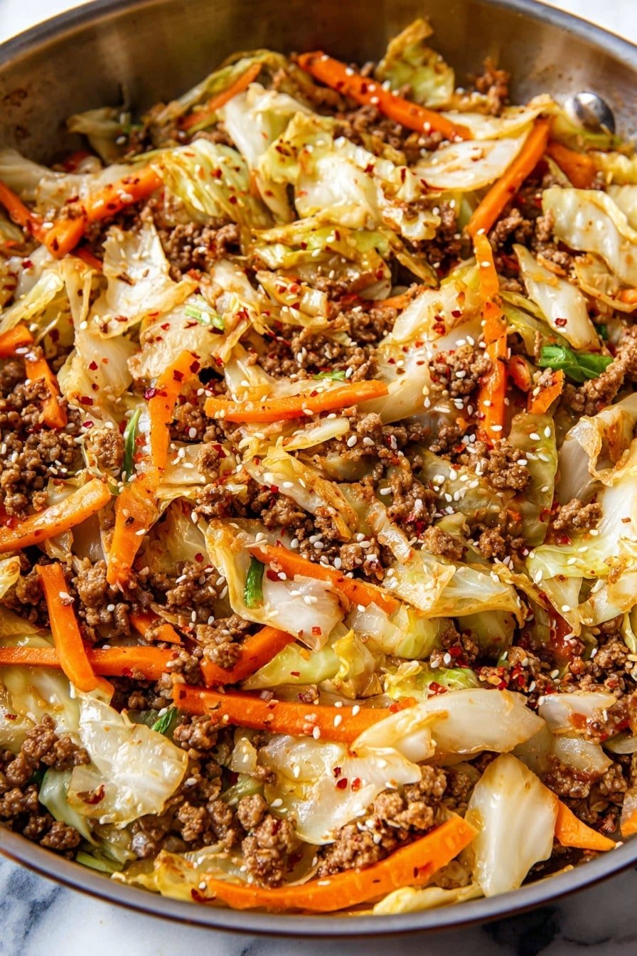 The image shows a close-up of a cooked dish in a dark pan, with several layers mixed together. The base layer is light-colored cabbage pieces with a soft, slightly wilted texture, mixed with thin, bright orange carrot sticks, some of which are slightly charred. Scattered throughout are small, crumbly pieces of brown ground meat, cooked thoroughly. The dish is sprinkled with white sesame seeds and crushed red pepper flakes, adding small pops of light and red colors on top. The pan is set against a white marbled texture background. Photo taken with an iphone --ar 2:3 --v 7