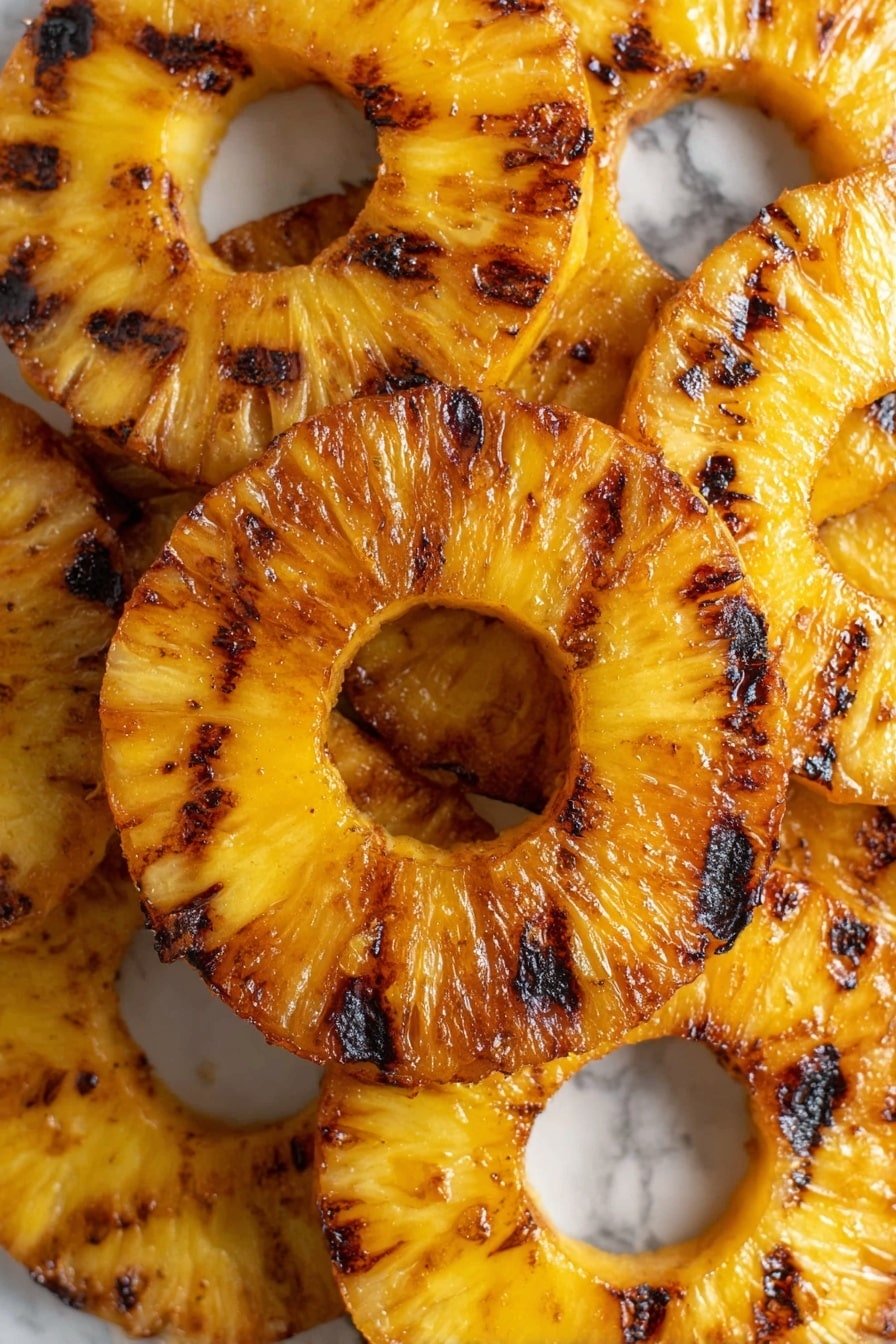 The image shows several round pineapple rings stacked closely together on a white marbled surface. Each ring is golden yellow with darker brown spots and lines from grilling, showing a slightly shiny texture from caramelized sugars. The grill marks are unevenly spread, adding a charred look to the surface. The pineapples overlap slightly, filling the frame with their bright, warm tones. Photo taken with an iphone --ar 2:3 --v 7