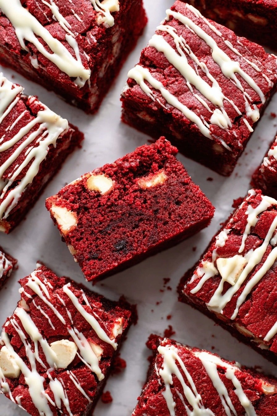 The image shows several square red velvet brownies arranged closely on a white marbled surface. Each brownie has a rich dark red color with a dense, moist texture. Inside the brownies, there are small white chunks scattered throughout. The top layer of the brownies has a light drizzle of white icing running diagonally and unevenly across them. Some brownies show a few crumbs on their edges. The surface beneath the brownies is smooth and clean, making the red color of the brownies stand out vividly. photo taken with an iphone --ar 2:3 --v 7