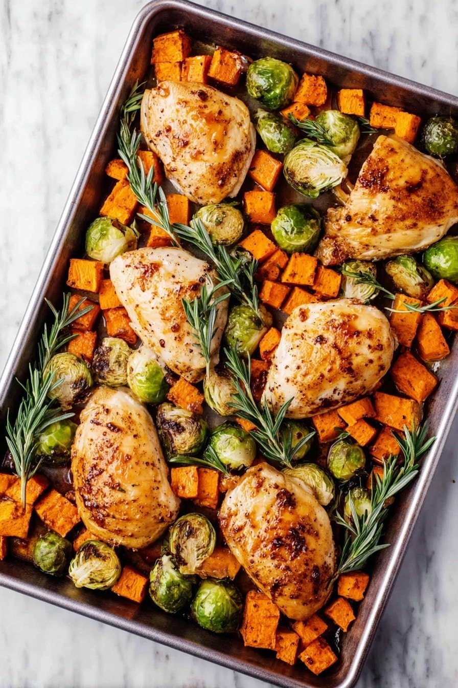 The image shows a black baking tray filled with two golden-brown cooked chicken pieces placed near the center. Around the chicken, there are many small orange sweet potato cubes and green Brussels sprouts, some whole and some cut in half, all cooked with slight charring. Fresh green rosemary sprigs are scattered on top, adding a touch of color. The tray sits on a white marbled surface photo taken with an iphone --ar 2:3 --v 7