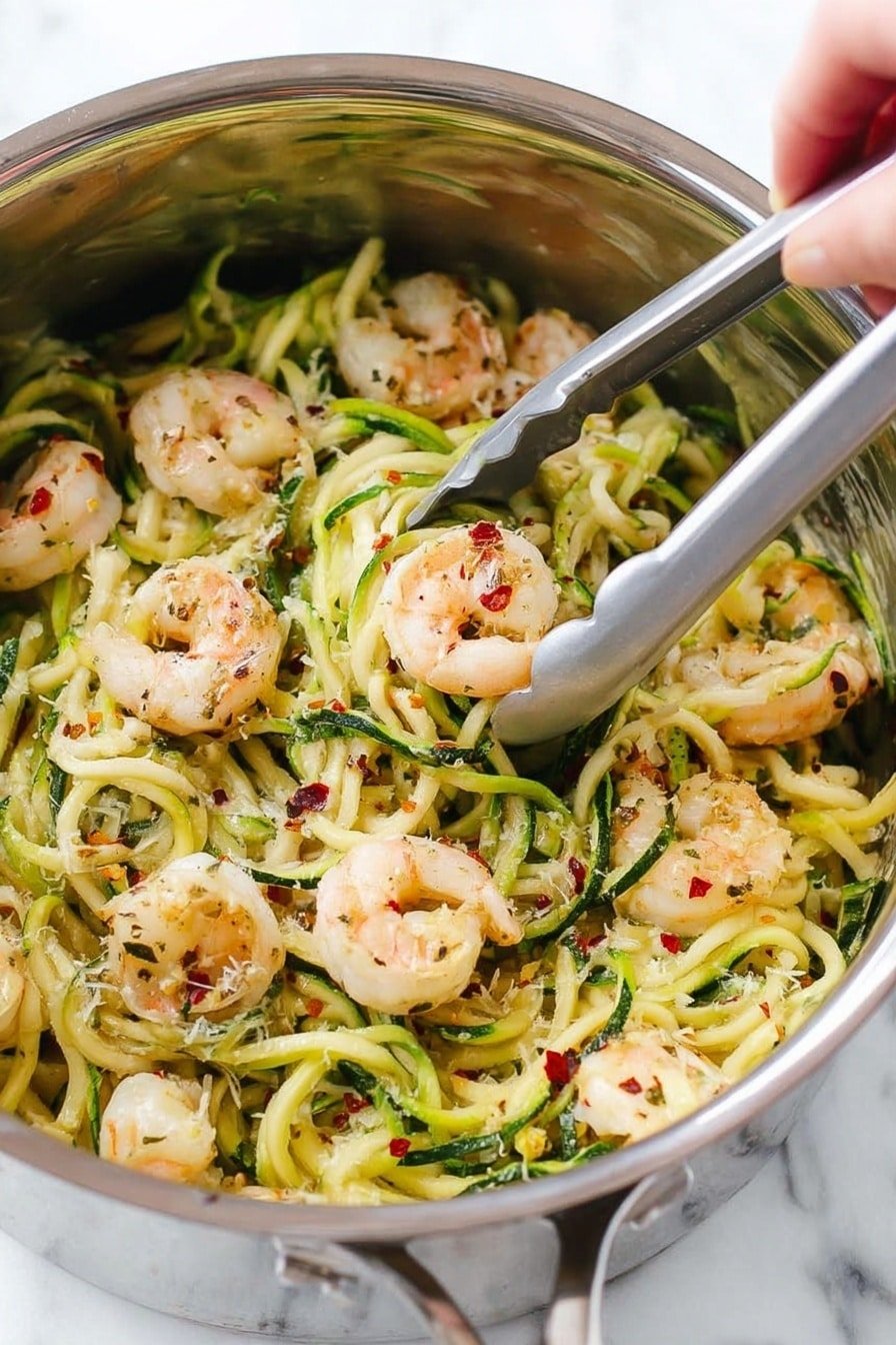 The image shows a stainless steel pot filled with spiral-shaped zucchini noodles mixed with cooked shrimp. The shrimp are pinkish-white with char marks, and the zucchini noodles are bright green and light yellow in color. Scattered on top are small red chili flakes and white grated cheese, adding texture and color contrast. A woman's hand is holding silver tongs picking up a piece of shrimp among the noodles. The background is a white marbled texture. photo taken with an iphone --ar 2:3 --v 7