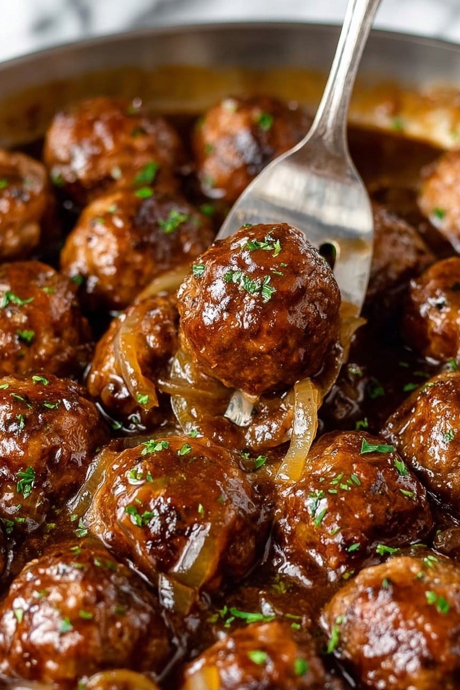The image shows a close-up of many small round meatballs cooked in a rich dark brown sauce with pieces of translucent cooked onions spread evenly throughout. The meatballs have a browned crust and look moist and juicy with a shiny glaze from the sauce. Small green herb pieces are sprinkled on top for color. A silver fork is piercing one meatball near the center, lifting it slightly above the rest. The dish sits on a white marbled texture background, highlighting the warm tones of the food. The sauce has a smooth and glossy texture that covers the meatballs partially. photo taken with an iphone --ar 2:3 --v 7